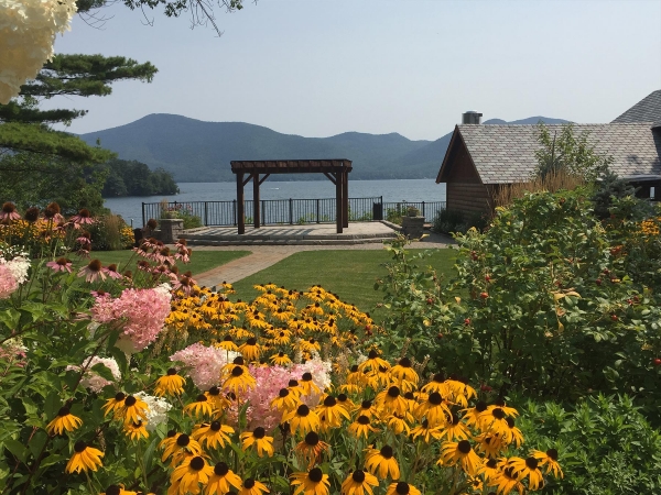 Landscaped yard with patio with pergola overlooking lake