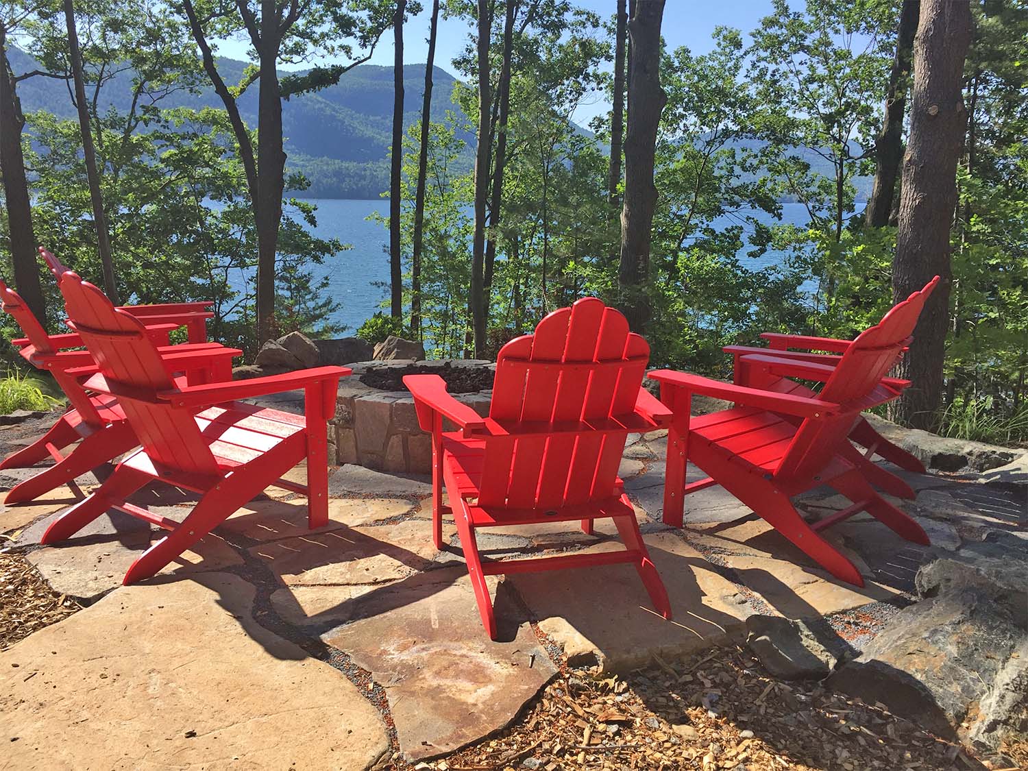 Red adirondack chairs overlooking Lake George